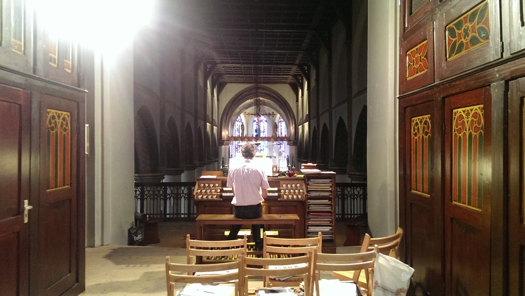Een kijkje in het schip van de Sint-Jansbasiliek in Oosterhout over de rug van organist Rens Swart